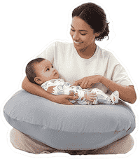 Mother sitting with the grey pillow around her waist, supporting her baby while nursing